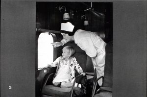 Here one of the original stewardesses points out the scenery to a youthful sky-traveler. Notice that stewardess uniform, showing the influen
