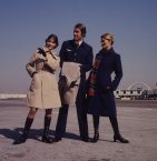 In winter, a navy wool coat was worn with a long striped double knit scarf in red, blue and green. For summer a tan trench coat was issued. 