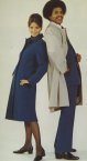 In winter, a navy wool coat was worn with a long striped double knit scarf in red, blue and green. For summer a tan trench coat was issued. 