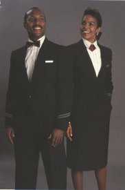 The full length serving garment was navy double breasted with burgundy accents and tied with a wrap belt in back. On International flights i