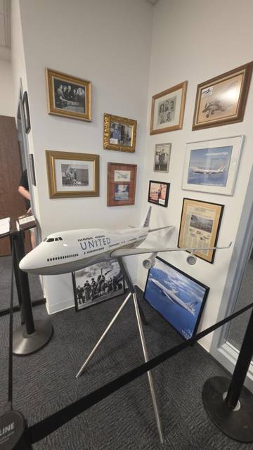 Model 747 beside a wall of framed airline photographs
