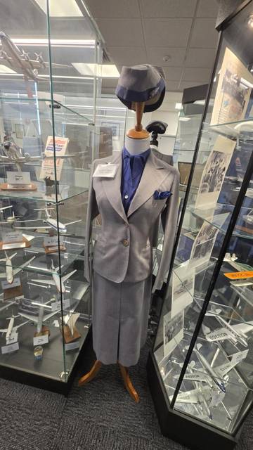 Gray stewardess uniform with cap and blue scarf