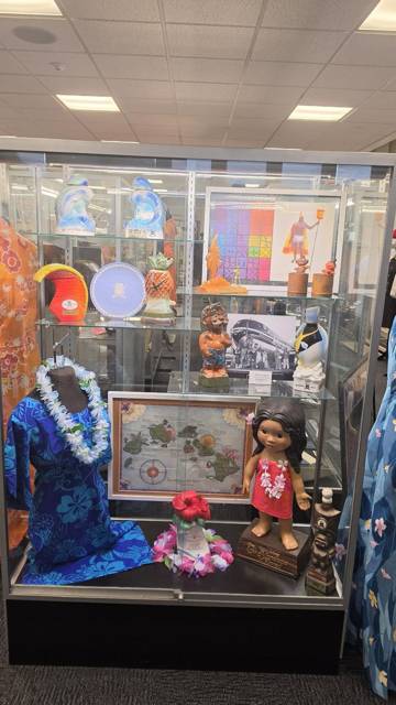 Island-themed display: leis, doll, map and keepsakes