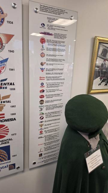 Timeline plaque beside an early stewardess cape and cap